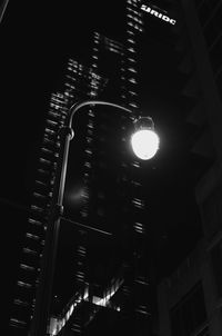 Low angle view of illuminated lights against buildings at night