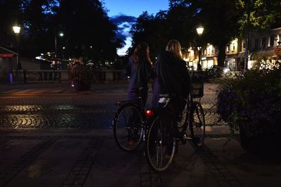 Rear view of woman on bicycle at night