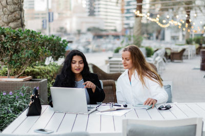 Two women discuss a common project during their lunch break. business, collaboration.