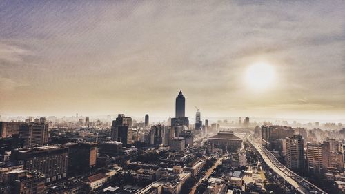 High angle shot of cityscape against clouds