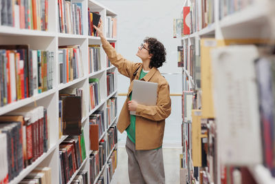 Portrait of young woman standing in library