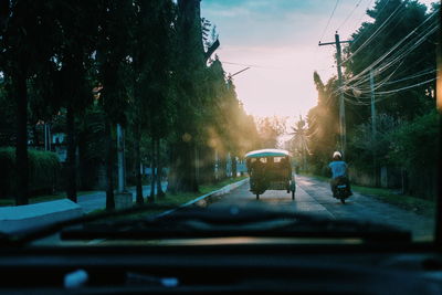 Man cycling on road against sky