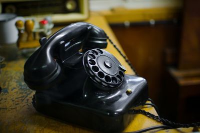 Close-up of vintage black telephone on table