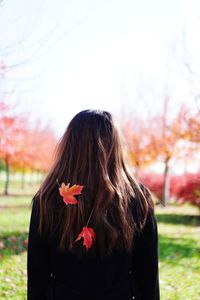 Woman standing by flowers against blurred background