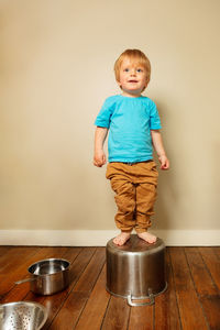 Portrait of cute boy standing against white background