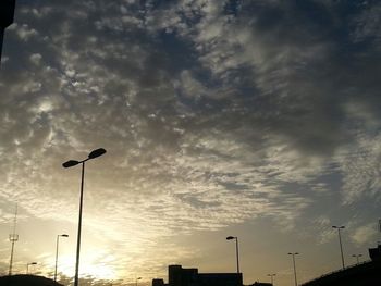 Low angle view of street light against cloudy sky