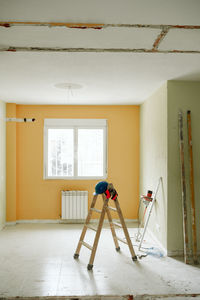 Ladder, blue protective helmet and ear defenders at construction site. home improvement, renovation