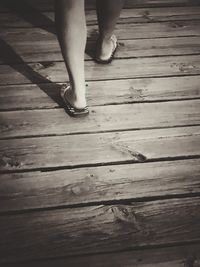 Low section of woman standing on wooden floor