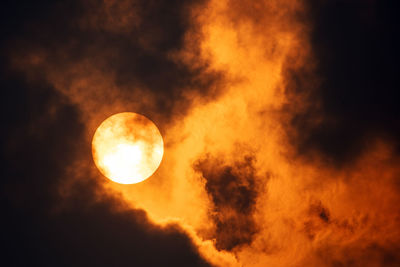 The sun behind forest fire smoke at sunrise