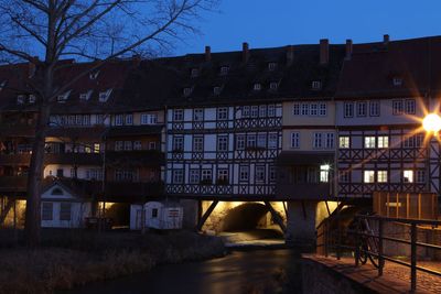 Illuminated buildings against sky at dusk