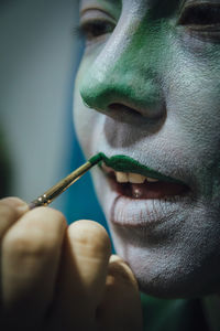 Close-up portrait of man holding leaf