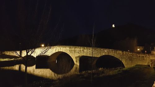 Arch bridge against sky at night