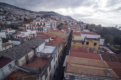 High angle view of houses in town against sky