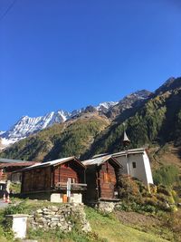 Scenic view of houses and mountains against clear blue sky