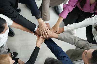 Low section of friends stacking hands