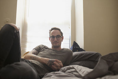 Young man lying on bed