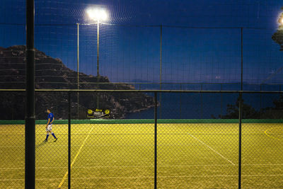 Man playing soccer field against sky