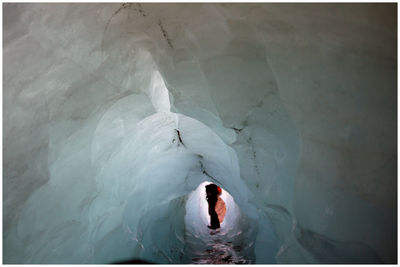 Low section of person standing at entrance on ice cave