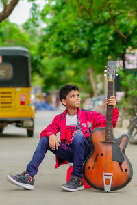 Full length of a boy playing with guitar