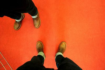 Low section of man standing on red carpet