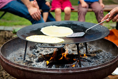 Cropped image of hands preparing food on barbecue