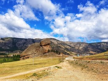 Scenic view of land and mountains against sky