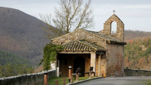 Built structure by mountain against sky