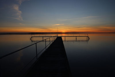 Pier over sea against sky during sunset