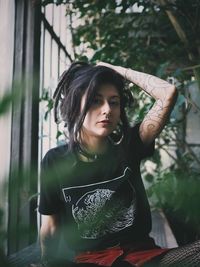 Portrait of beautiful young woman standing against blurred background