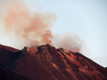 Smoke emitting from volcanic mountain against sky