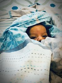 Portrait of baby lying down on bed at home