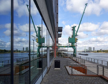 Pier at harbor against sky in city