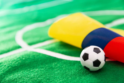 Close-up of small soccer ball with flag on green textile