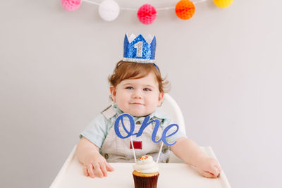 Portrait of cute baby boy against wall