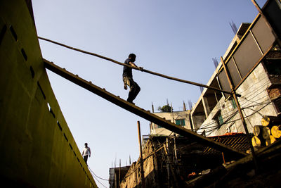Low angle view of man on rope against sky