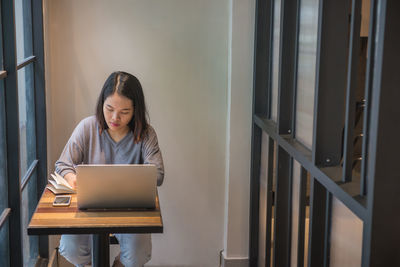 Woman using laptop at cafe