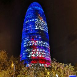 Low angle view of illuminated skyscraper against sky at night