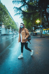 Full length of woman with umbrella in city