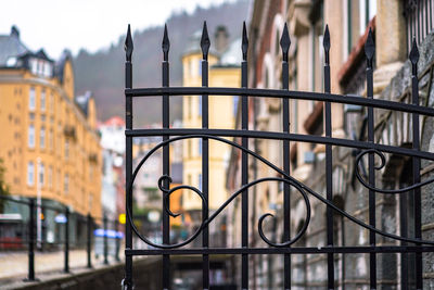 Close-up of railing against buildings in city