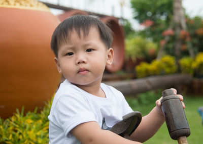 Portrait of cute boy sitting at park