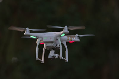 Rear view of professional quadcopter camera drone hovering. looking from behind