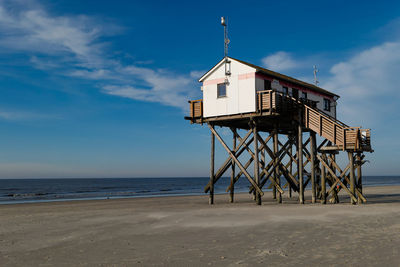 Lifeguard hut on beach against sky