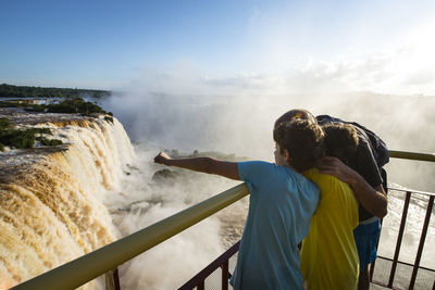 Father with sons looking at iguacu falls