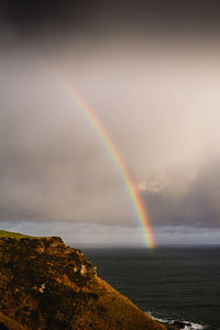 Scenic view of rainbow over sea against sky