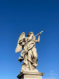 Low angle view of statue against blue sky