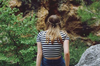 Rear view of woman sitting in forest