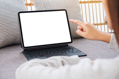 Midsection of woman using laptop at home