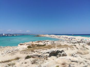 Scenic view of beach against clear blue sky