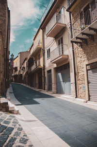 Street amidst buildings in city against sky