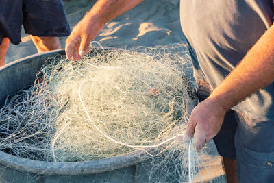 Midsection of man fishing net